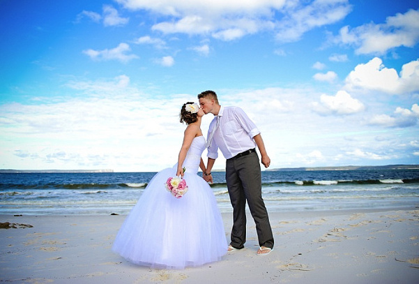 一对新人在纯白的Hymas海滩上热吻。这里的沙由纯度近乎百分之百的石英组成，被吉尼斯世界纪录评为“世界上最白的沙”。图:idoidoweddings.com.au